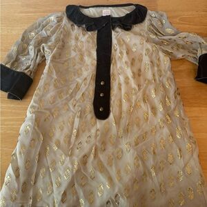 Lauren Moffatt gold shirt with black accents.